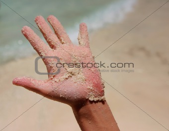 a white wet sand in sunburned hand