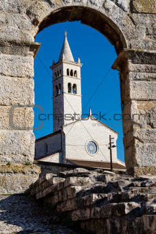 White Church Framed in the Arch of Ancient Roman Amphitheater 