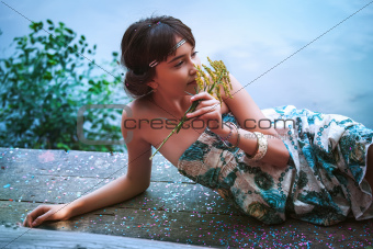 Girl sitting by a lake