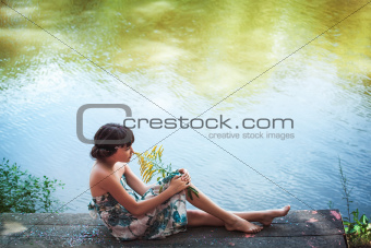 Girl sitting by a lake