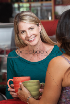 Smiling Blond Woman with Friend in Bistro
