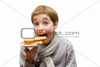 Portrait of a cute boy eating a waffle - isolated on white