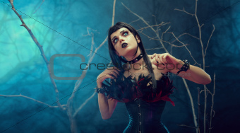 Pretty gothic girl wearing tight feather corset 