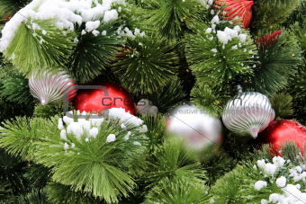 Colorful ornaments tucked into green pine boughs.