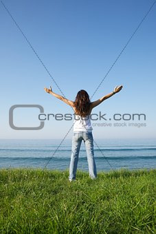 cross woman at grass seashore