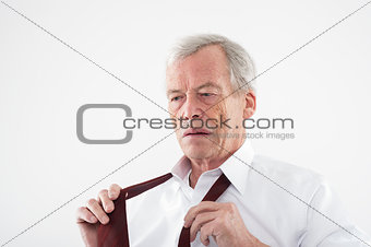 Elderly man putting on his tie