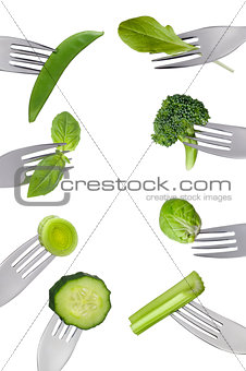 border of fresh green vegetables isolated on forks