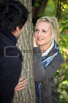 a blonde woman watching lovingly a man in the forest