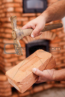 Mason hands with brick and hammer