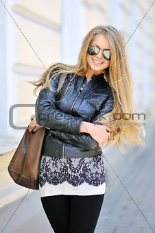 Portrait of young beautiful woman in sunglasses wearing black ja