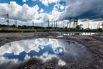 Cloudy Sky Reflected in Huge Road Puddle near Moscow, Russia