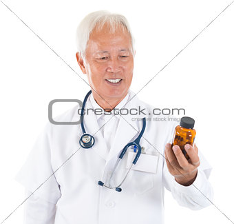 Asian senior doctor holding a bottle of pills