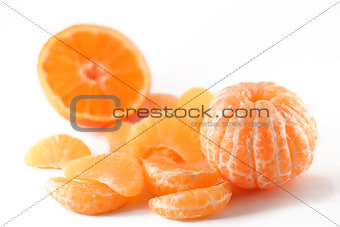 peeled mandarin and slices on white