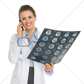 Smiling medical doctor woman speaking mobile phone and holding M