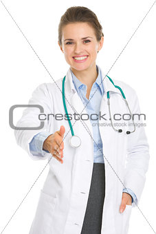 Smiling medical doctor woman stretching hand for handshake