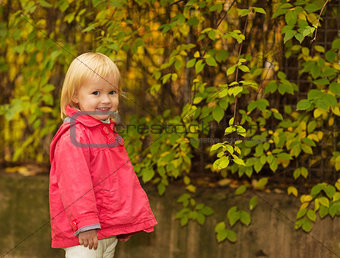 Portrait of baby in red coat outdoors