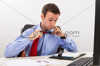 Stressed businessman having a hard day at office