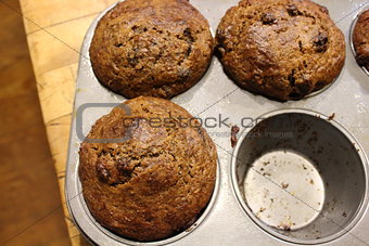 Bran muffins in tin on old table