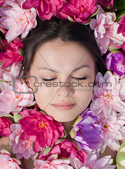 Young pretty woman among pink lilies