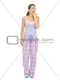 Young woman in pajamas yawing