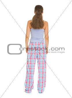 Full length portrait of young woman in pajamass. Rear view