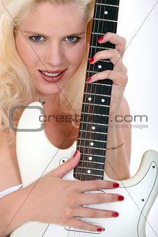 Blond woman holding electric guitar