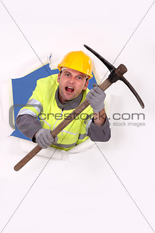Construction worker breaking through a barrier with a pickaxe