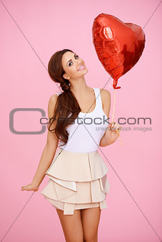 Vivacious sexy woman with heart balloon