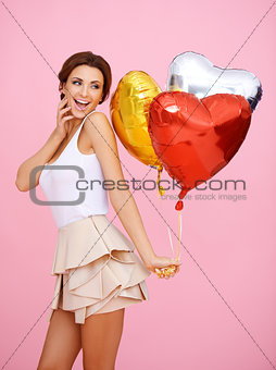 Vivacious woman with heart shaped balloons