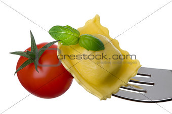 ravioli pasta tomato and basil on fork against white background