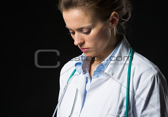 Portrait of thoughtful medical doctor woman isolated on black