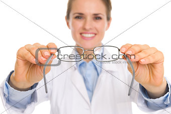 Closeup on medical doctor woman giving eye glasses