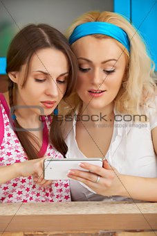 Girls looking at pictures on mobile phone