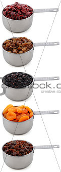 A variety of dried fruit in cup measures