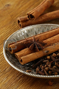 cinnamon, anise and clove on a silver plate