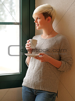 Looking out a window drinking coffee
