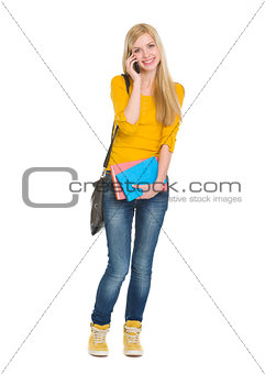 Full length portrait of happy student girl speaking mobile