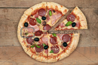 Sliced Deluxe Pizza on a wooden table