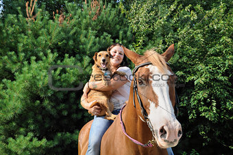 Young adult woman with her horse and dog