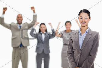Businesswoman smiling with enthusiastic co-workers