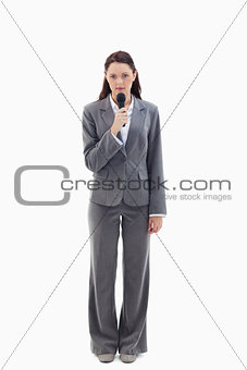 Serious businesswoman holding a microphone