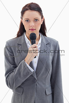 Close-up of a serious businesswoman holding a microphone