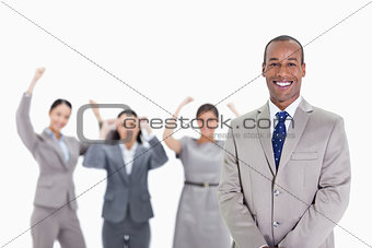 Happy businessman with enthusiastic co-workers in the background