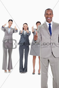 Business team smiling with thumbs up 