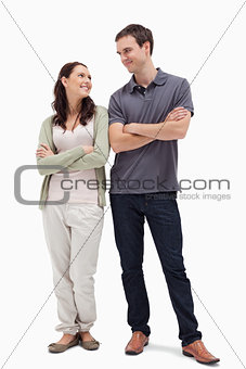 Smiling couple looking at each other and crossing their arms