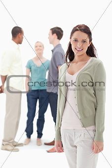 Woman smiling with her friends chatting behind