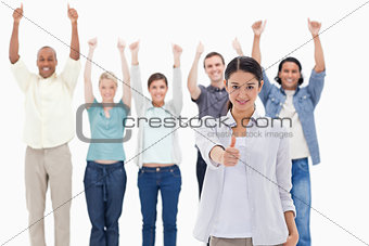 Close-up of a girl with people raising their arms and with their