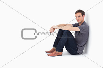 Man sitting against a wall 