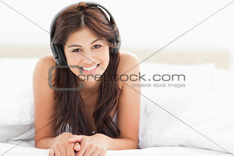 Woman tilting her head slightly while listening to music and smi