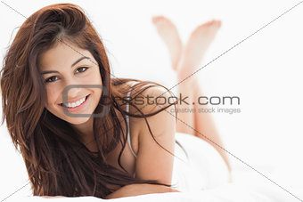 Woman lying down with her legs crossed and raised, smiling with 